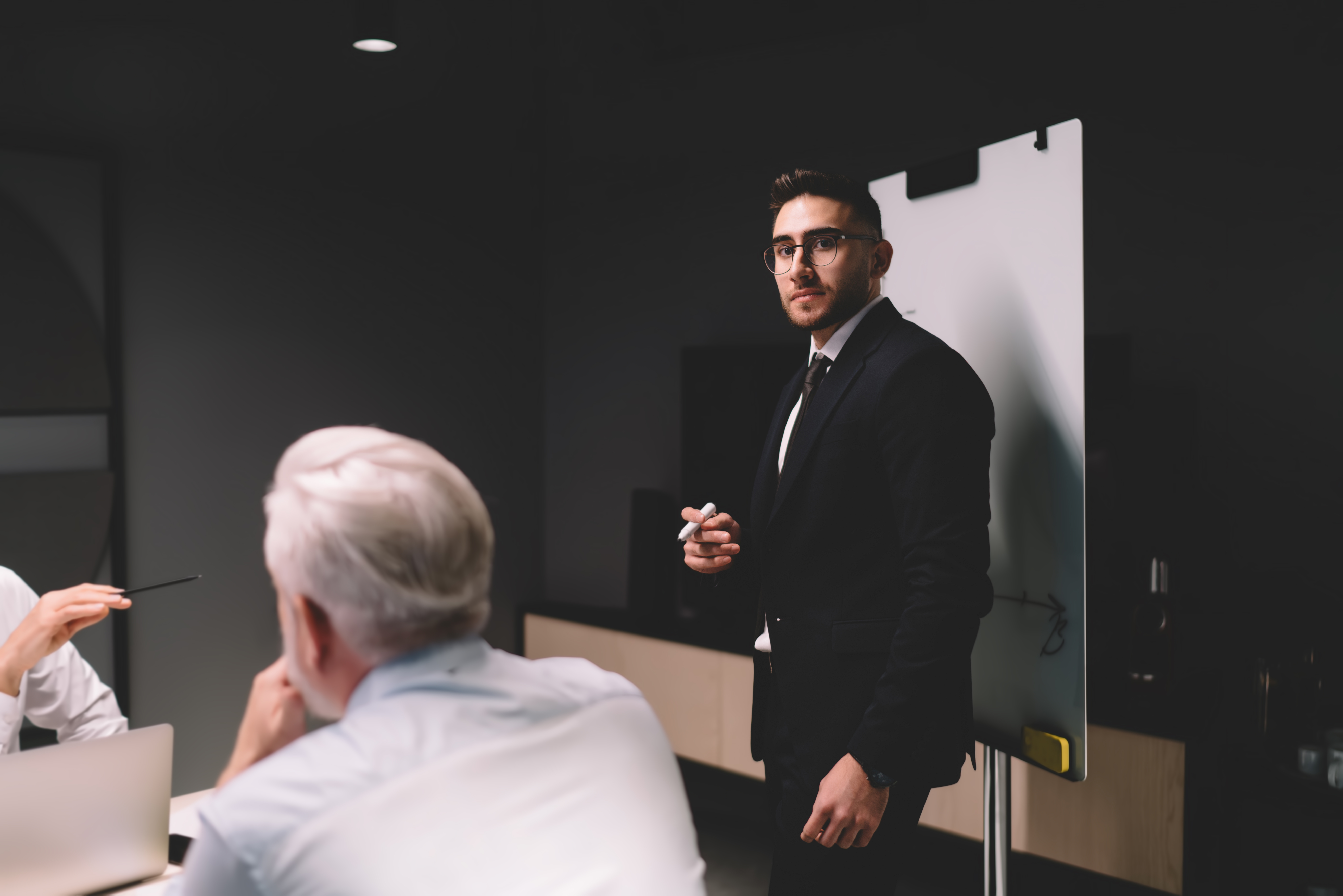 A young business professional taking charge of a team meeting in the boardroom.