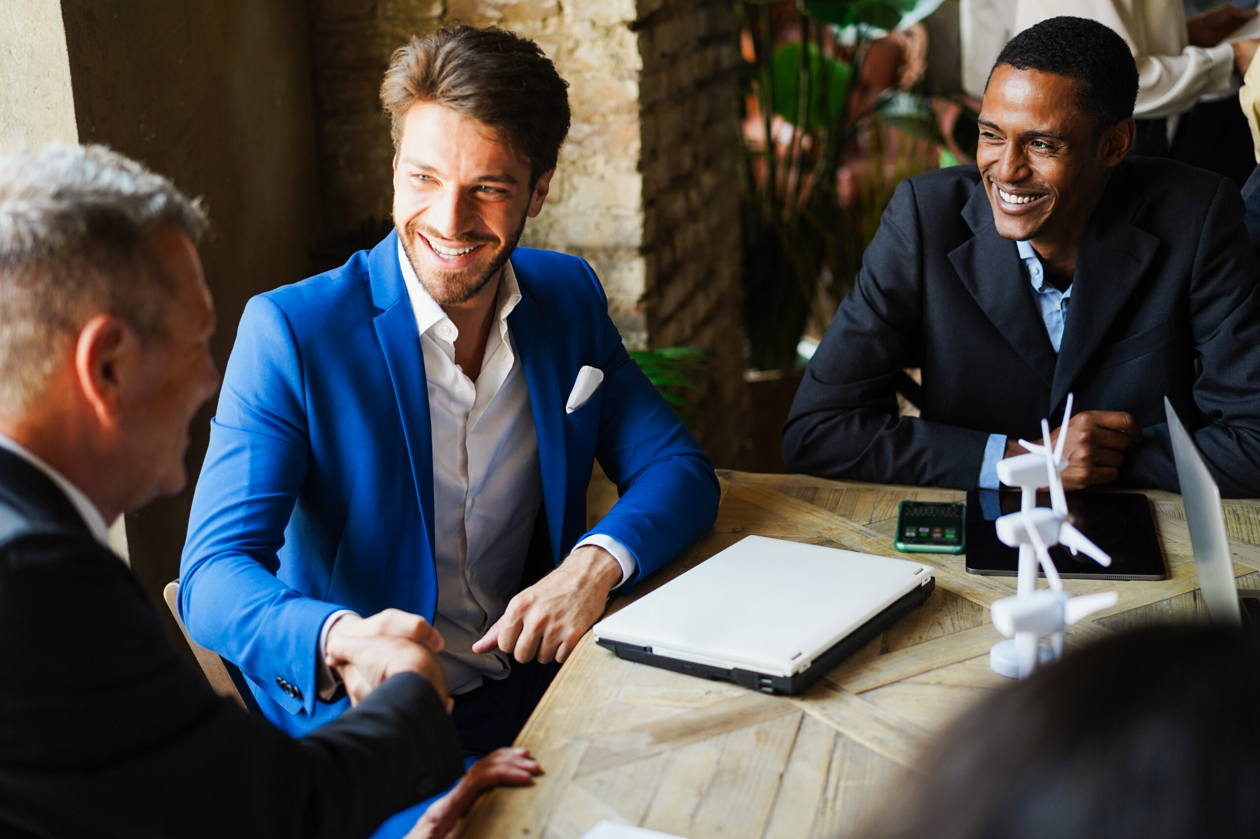 A group of business professionals meeting a client, shaking hands after a closed deal.